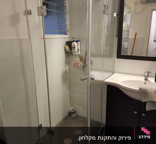 מקלחון זכוכית עם מוצרי רחצה ומקלחת